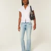 Calças de ganga bootcut com cintura baixa, lavagem média e bordado de borboleta