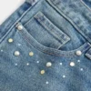 Calças de ganga bootcut de cintura baixa com lavagem média e tachas