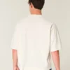 Camiseta de futebol americano com estampa gráfica, estilo universitário, folgada e pesada