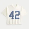Camiseta de futebol americano com estampa gráfica, estilo universitário, folgada e pesada