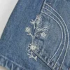 Mini-calções de ganga com lavagem média, bordados florais e cintura ultra baixa Mini-calções de ganga com lavagem média, bordados florais e cintura ultra baixa