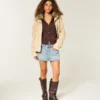 Mini-saia-calça de ganga com tachas, cintura baixa e lavagem média