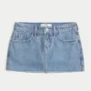 Mini-saia-calça de ganga curvilínea de cintura baixa e lavagem média Mini-saia-calça de ganga curvilínea de cintura baixa e lavagem média
